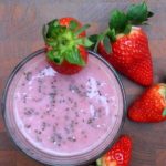 An image of Chia Seeds and Strawberry Milkshake [vegan] in a glass with strawberries around it.
