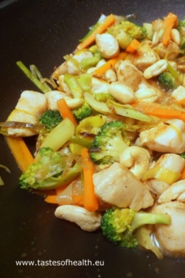 An image showing a close up of Chicken Stir-Fry with Broccoli and Cashew Nuts and carrots in a black wok