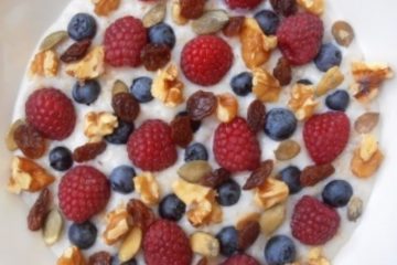An image of Delicious Fruity Porridge with raspberries, blueberries, walnuts and honey.