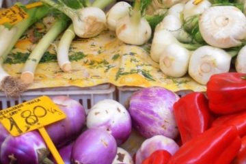 An image of a display of vegetables (red peppers, obergines, leeks, tomatoes) for a post about types of plant based diet (vegetarian, vegan, pescatarian, flexitarian, lactovegetarian) and what to eat to provide necessary nutrients