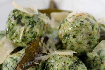 An image of a bowl of Spinach and Ricotta Gnocchi with shavings of Parmesan cheese and sage butter.