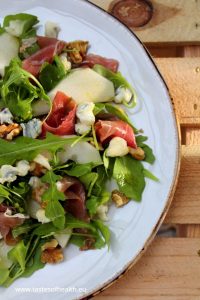 Pear and Gorgonzola Salad with Pecans, rocket and prosciutto on a white plate